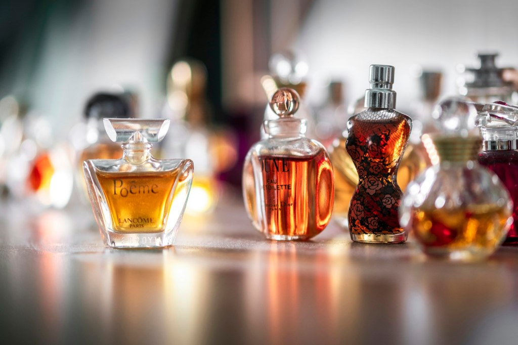 A clear glass perfume bottle in soft focus, evoking American perfume houses