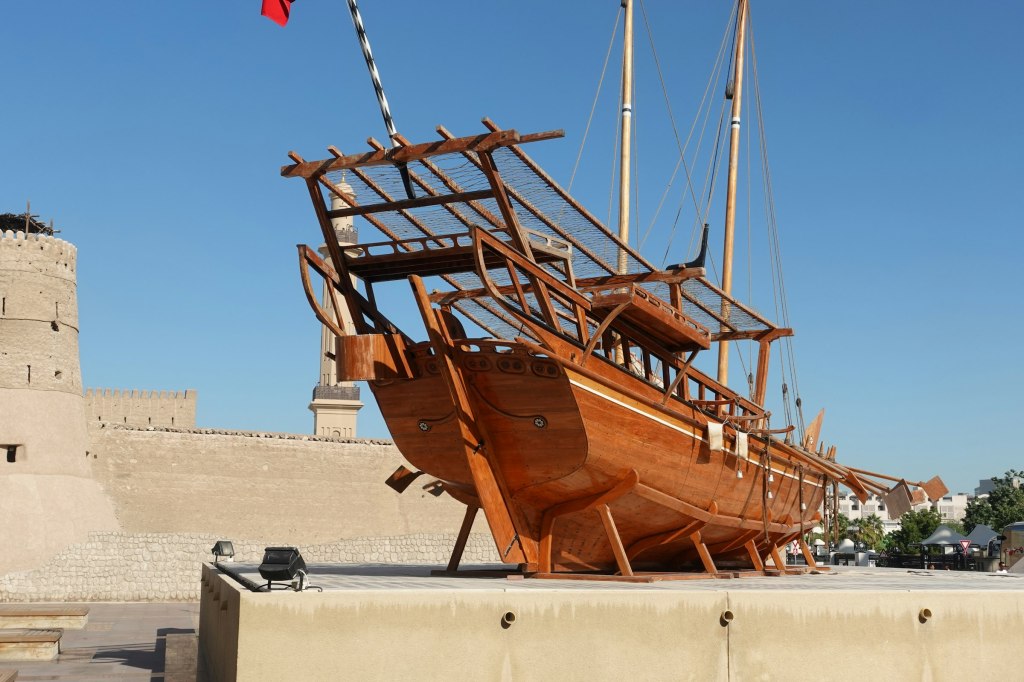 A traditional wooden dhow on white sand, recalling the Pearling Path heritage of Muharraq, Bahrain