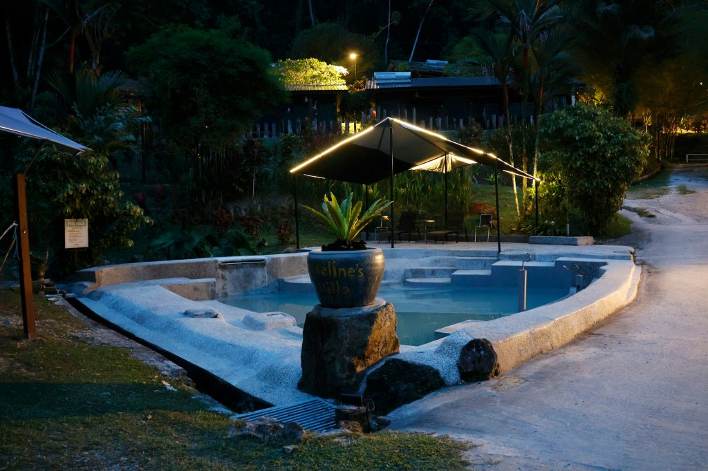 An outdoor hot spring pool at night with soft lighting, evoking Calistoga hot springs
