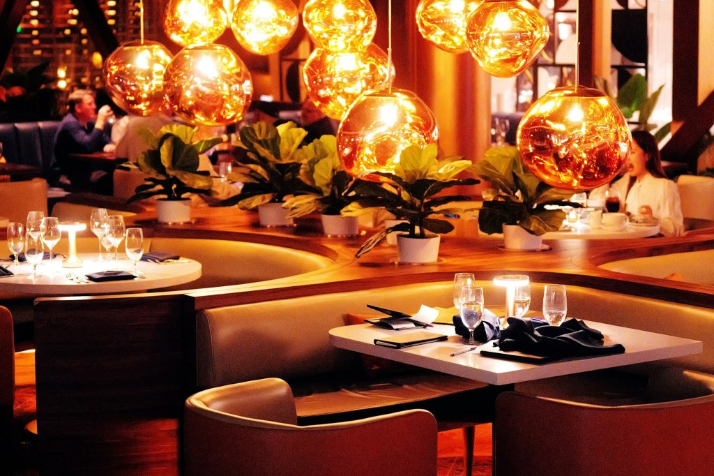 An elegant restaurant dining room in warm light, evoking fine dining in Montreal
