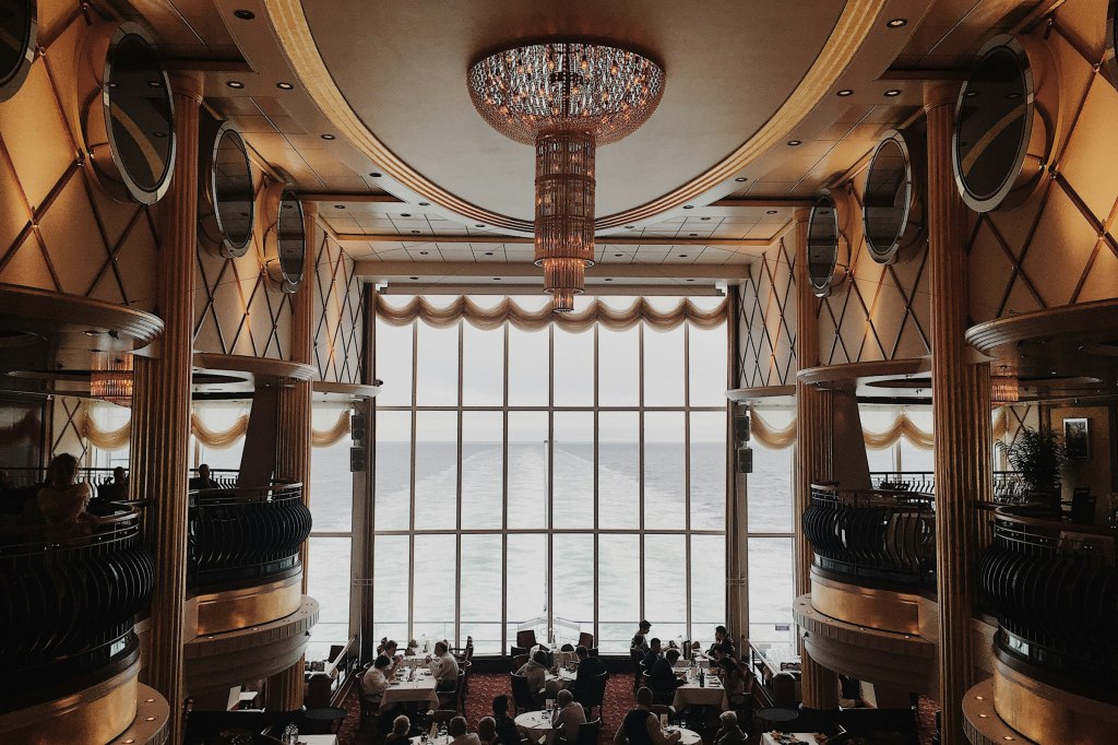 A crystal chandelier above an elegant restaurant dining room, evoking fine dining in New York