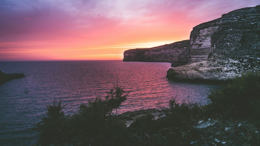Rocky Mediterranean coastline at golden hour, evoking Gozo in Malta