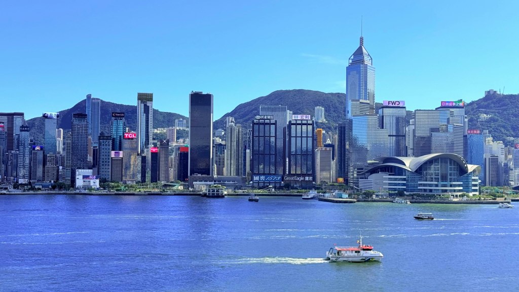 Modern Hong Kong skyscrapers rising beside a blue harbor