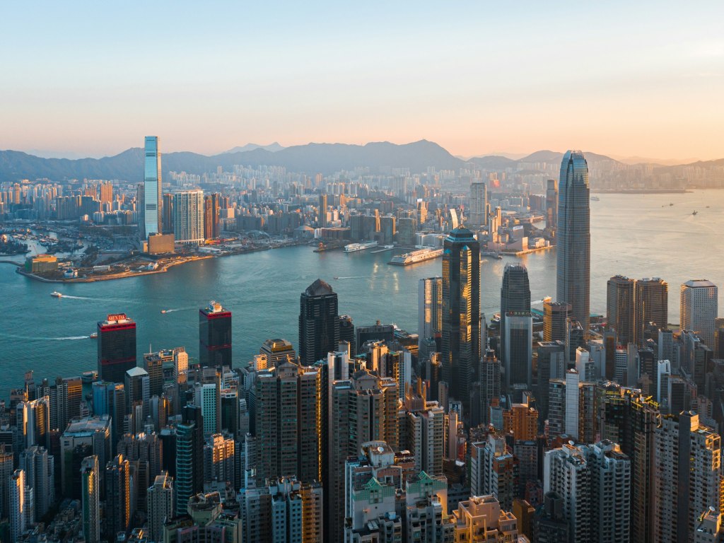 Hong Kong skyline across Victoria Harbour in golden hour light
