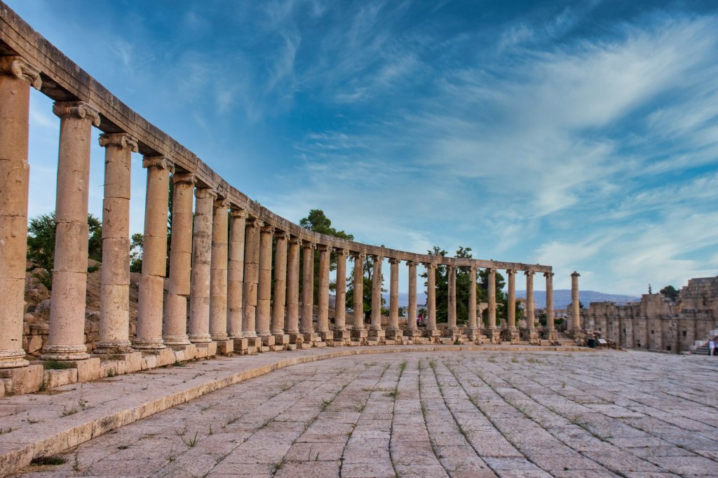 Roman columns under a blue sky in the ancient city of Jerash, Jordan