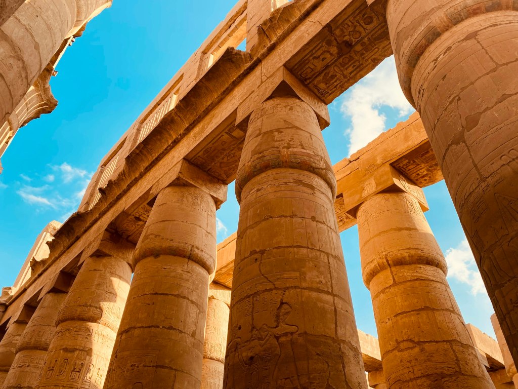 Sandstone columns under a blue sky at a temple in Luxor, Egypt