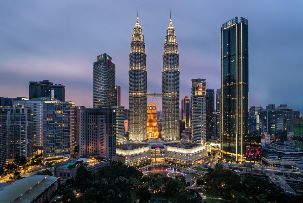 Petronas Towers glowing above a park in Kuala Lumpur, Malaysia