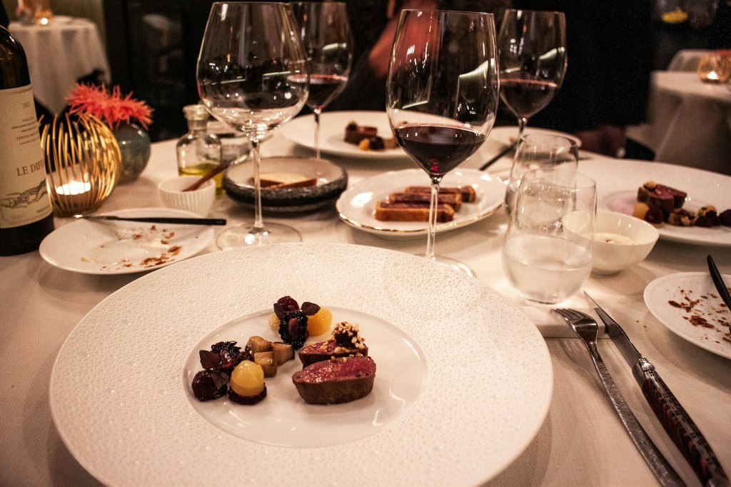 A table set with wine glasses and tasting-menu plates, evoking fine dining in Lisbon