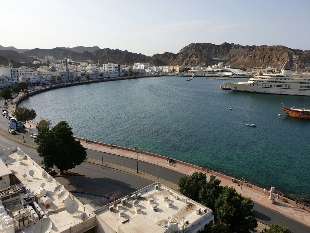 Calm blue bay ringed by rugged Hajar mountains near Muscat, Oman