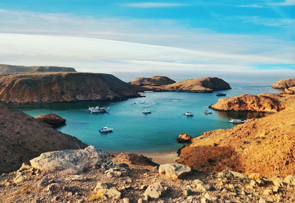 Rock formations meeting the blue sea along the coast near Muscat, Oman