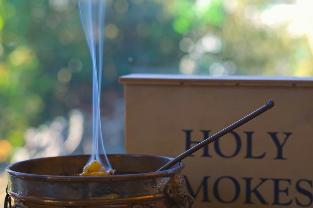 Fragrant white smoke rising from a metal incense burner, a frankincense tradition of Oman
