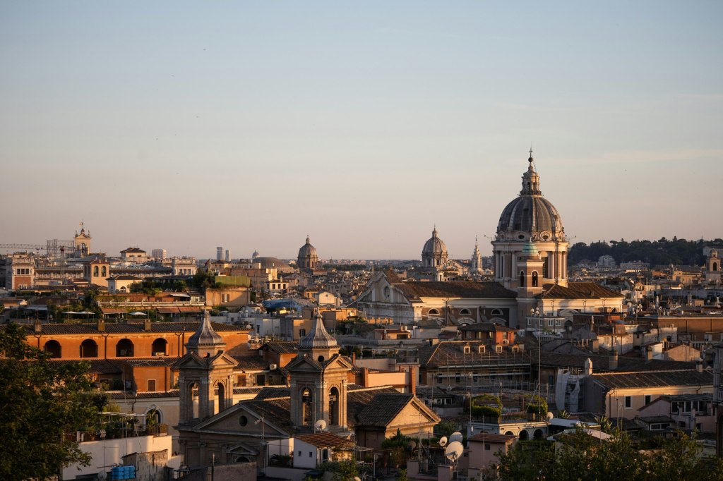 Rome cityscape with domes and terracotta rooftops at golden hour