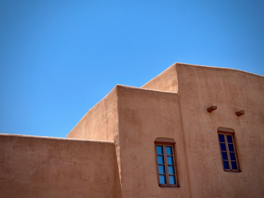 An adobe building against a bright blue sky in Santa Fe, New Mexico