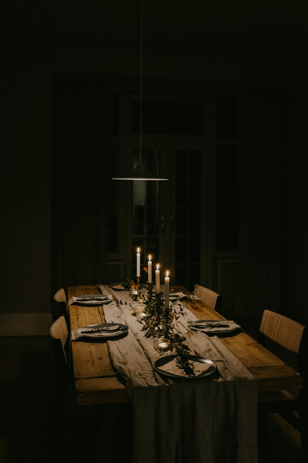 Lit candles on an elegantly set dining table