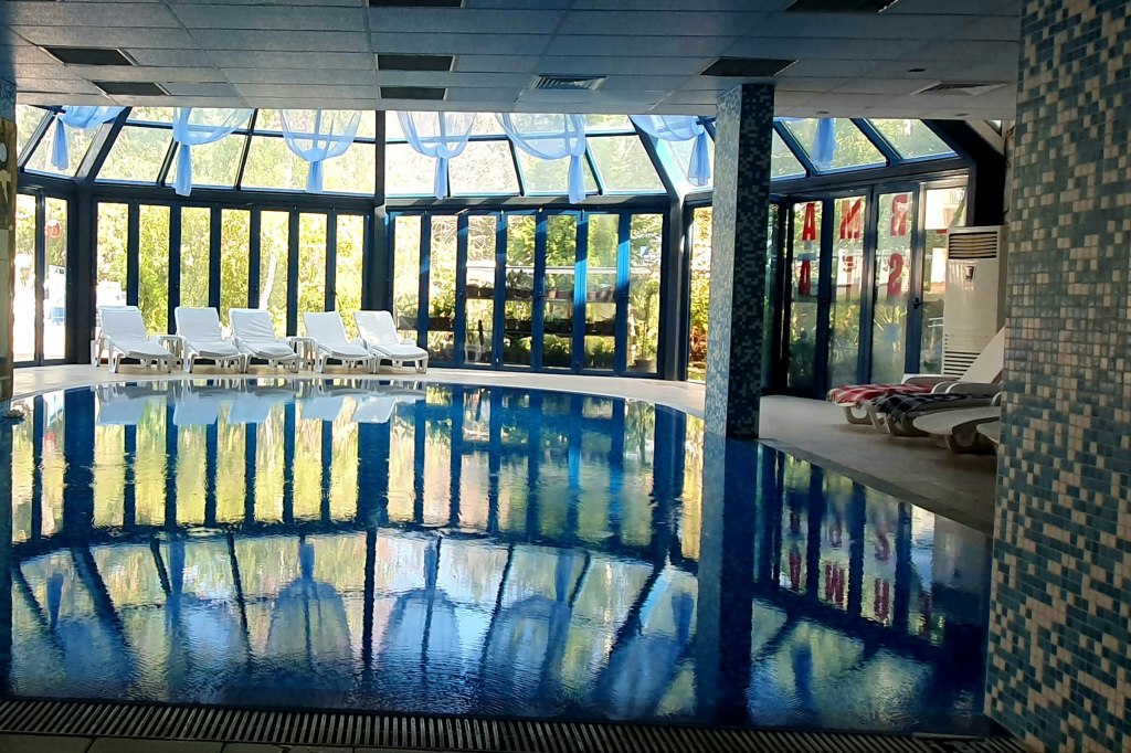A large indoor thermal pool beneath a skylight, evoking Portugal's historic spas