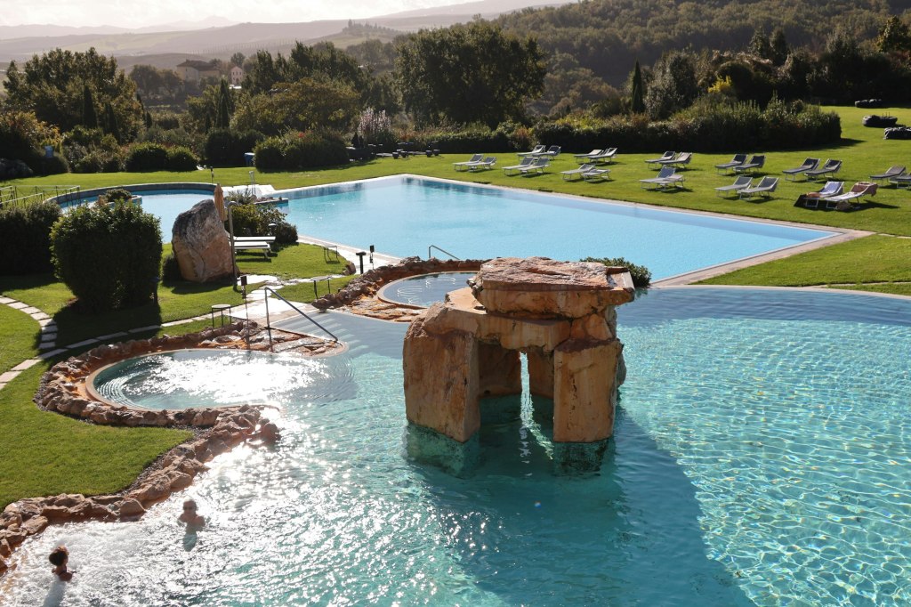 Thermal spa pool surrounded by green Tuscan countryside in Italy