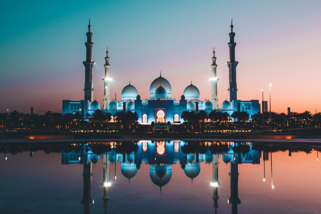 Sheikh Zayed Grand Mosque reflected in a pool at low sun in Abu Dhabi