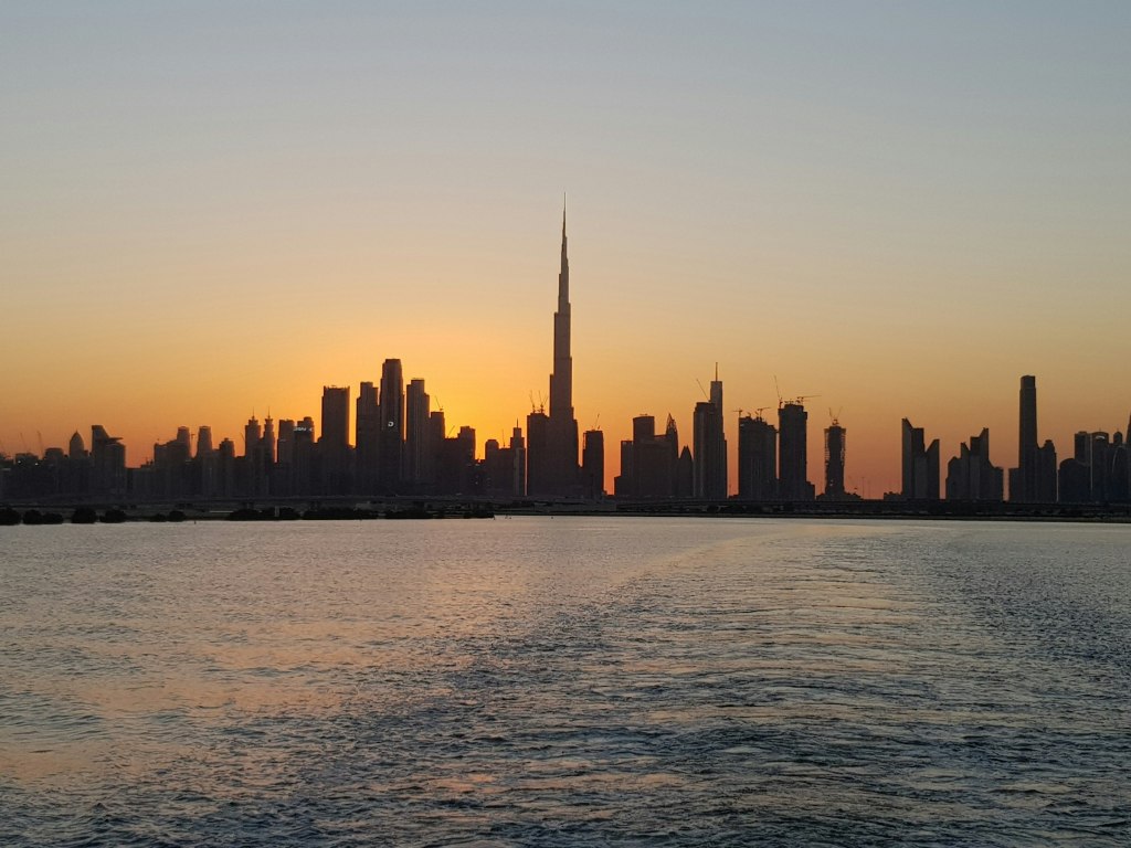 City skyline across the water at sunset in the United Arab Emirates