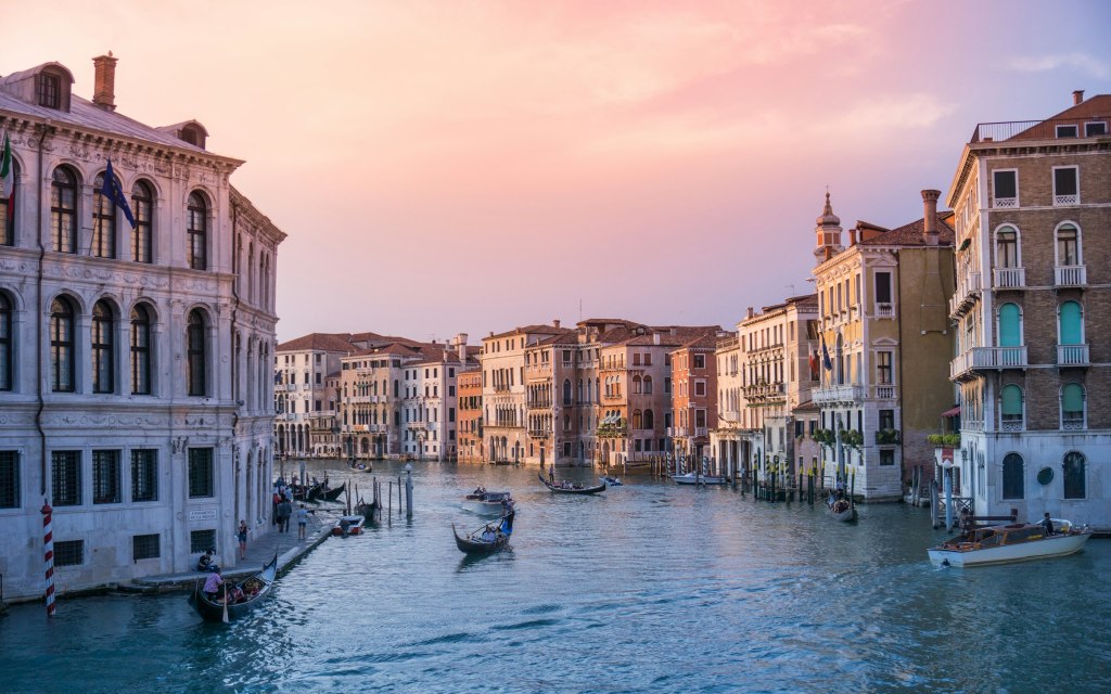 Gondolas on the Grand Canal in Venice under a warm evening sky